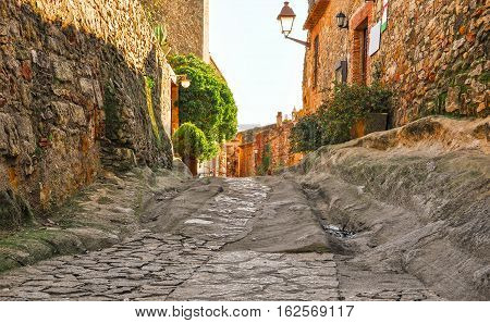 A street in the old town of Peratallada, Catalonia, Spain. Medieval street in the mediaval town in Europe.  Panoramic view of old town  in beautiful evening light at sunset