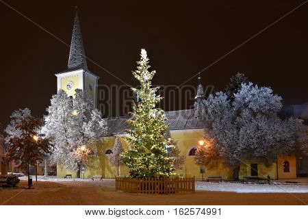 Beautiful Night Winter Photo Christmas Tree With Church And Snow.