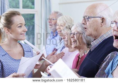 Group Of Seniors With Teacher Singing In Choir Together