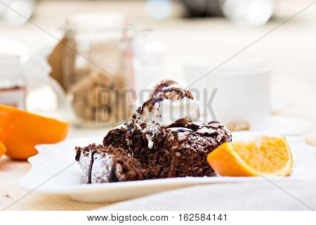 Warm dessert chocolate cake Fondant served on plate with ice-cream ball almond chips mint icing citron cacao