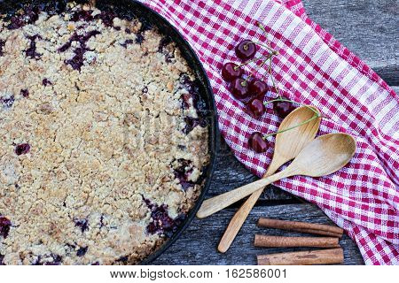 Homemade Cherry crumble and cherries on an old wooden table background.Selective focus.
