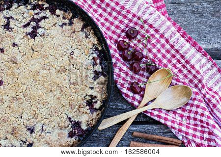 Homemade Cherry crumble and cherries on an old wooden table background.Selective focus.