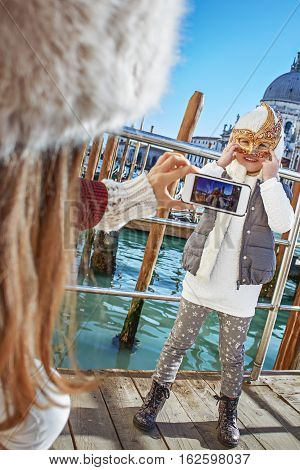 Mother Taking Photo Of Child Wearing Venetian Mask, Venice