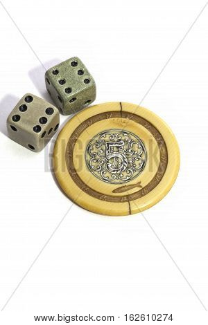 Lucky vintage gambling dice showing double six and a generic poker chip showing the number five. From a collection of antique gambling pieces.