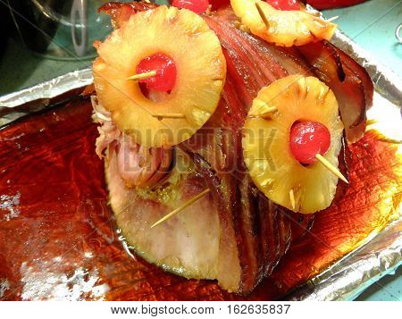 Christmas Ham covered in glaze and cherries and pineapples.