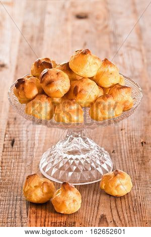 Group of sweet cream puffs on glass tray.