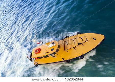 Panning motion blurred shot of speeding Yellow Pilot Boat at Sea