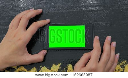 Woman using horizontal smartphone with green screen. Close up shot of woman's hands with mobile Close up shot of woman's hands with mobile