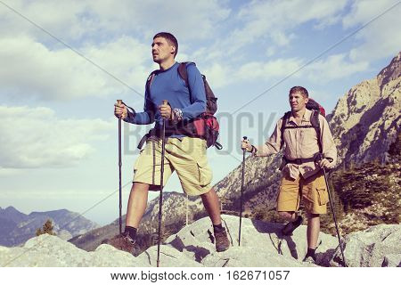 Summer hiking in the mountains with a backpack .