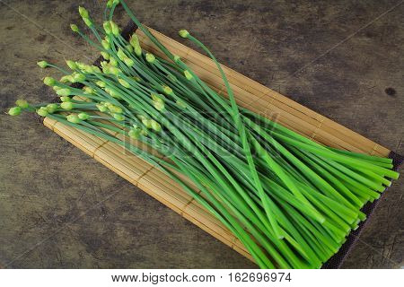 bunch of fresh chives on a wooden cutting board