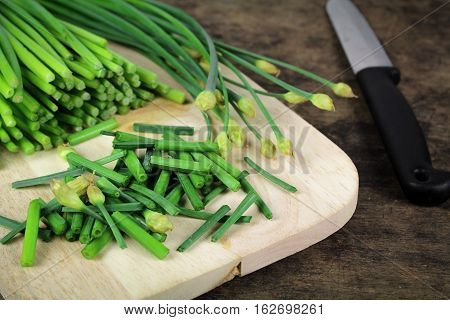 bunch of fresh chives on a wooden cutting board