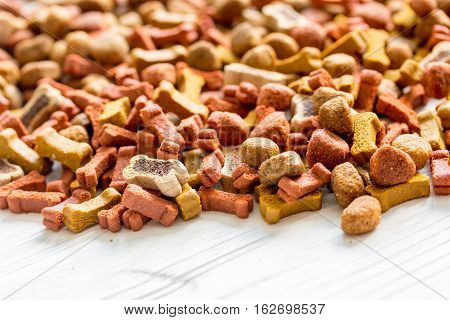 dry dog food in bulk on wooden background close up.