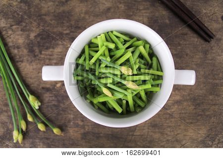 bunch of fresh chives on a wooden cutting board