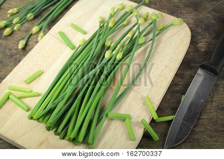 bunch of fresh chives on a wooden cutting board