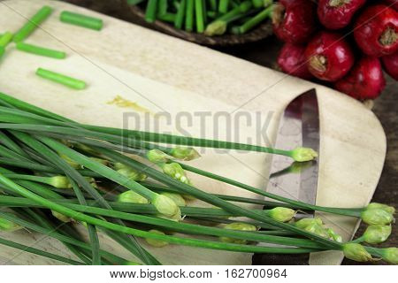bunch of fresh chives on a wooden cutting board
