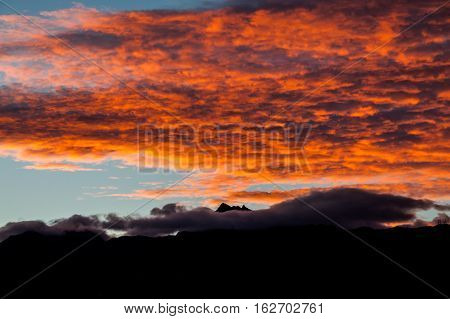 Sunset with orange clouds over the mountains