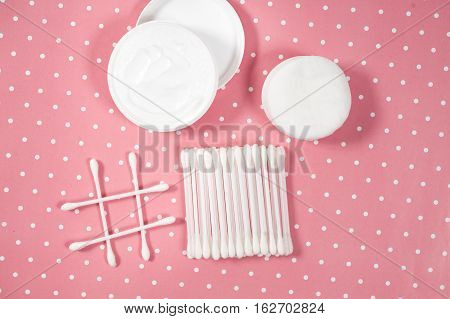 facials skin care. cotton pads and buds on the pink backgroung
