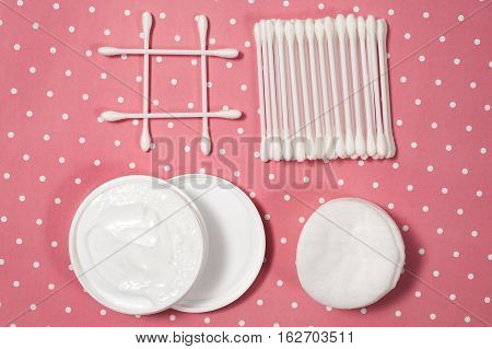 facials skin care. cotton pads and buds on the pink backgroung