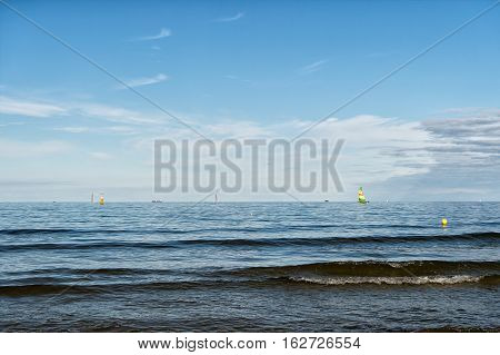 modern yacht or sailing boat or vessel sails by wind on sea water waves surface inshore on blue sky