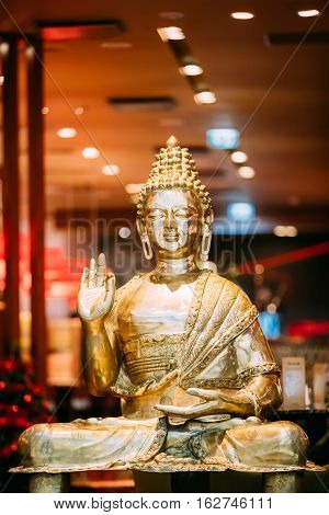 Golden Statue Of Buddha Sitting In Lotus Position With Raised Right Arm Gesture Showing Dispute, Explaining Teachings Of Buddha Vitarka Mudra.