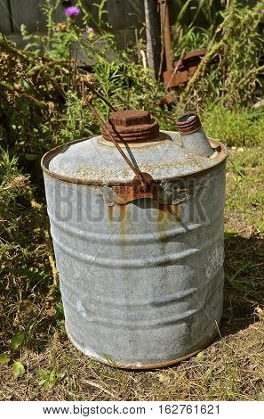 An old rusty five gallon gas and oil can used for transporting gas and oil.