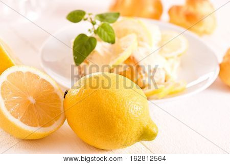 Lemon Profiteroles with lemon fruit on wooden table.