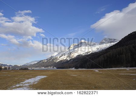 amazing landscape scenic view of Engadin valley in Switzerland Sils Maria village with snow on Alp mountains and frozen ground on a cold sunny winter day in tourism and holiday destination