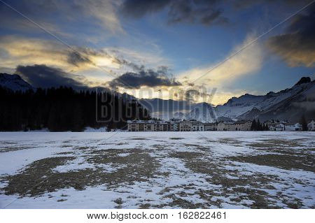 amazing landscape scenic view of Engadin valley in Switzerland Sils Maria village with snow on Alp mountains and frozen ground on a cold winter sunset in tourism and holiday destination