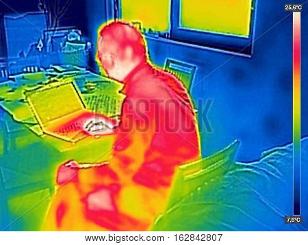 Infrared thermography image showing the heat emission when man used notebook