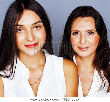 cute pretty teen daughter with mature mother hugging, fashion style brunette makeup close up, real happy family