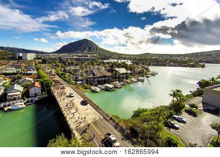 Aerial bird's eye view of Hawaii Kai as Honolulu Marathon participants traverse over a bridge with Koko Head in the background