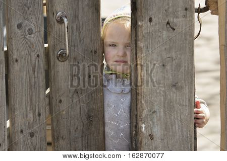 STINKA UKRAINE - APRIL 14 2016 - sad little girl looks out from the wicket door by hand on April 14 2016 in Stinka village.