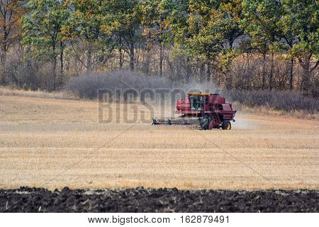 Harvester is working in the field during harvest time.