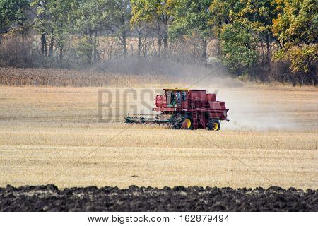 Harvester is working in the field during harvest time.