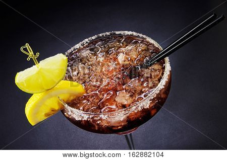 Cocktail with ice and lemon in a glass.