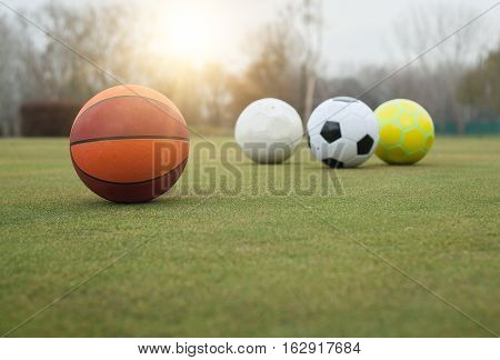 Various sports balls on grass field outdoor