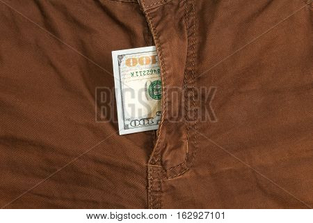 hundred dollar bill inside codpiece brown jeans closeup