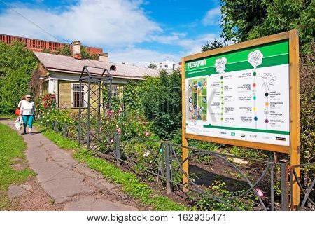 SAINT-PETERSBURG, RUSSIA, AUGUST 3, 2016: People near board with the different types of roses in the rosarium of Peter the Great Botanical Garden (Botanic Gardens of the Komarov Botanical Institute)