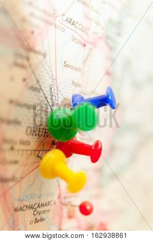 Travel destination points on a map indicated with colorful thumbtacks and shallow depth of field with space for copy