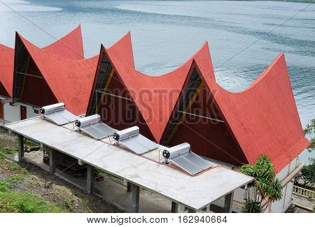Solar Water Heater supply electricity to batak-style houses with red roofs, Lake Toba, Indonesia.