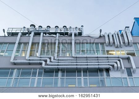 Large number of metal aluminum piping fixed to the facade of the building where a lot of Windows.