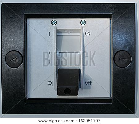Electric circuit breaker on the front panel of the electrical Cabinet. Around him a black plastic frame for protection and beauty.