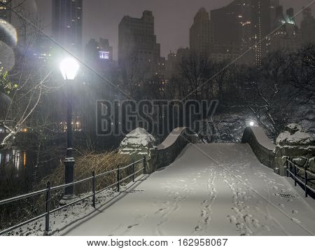 Gapstow Bridge is one of the icons of Central Park Manhattan in New York City during snow storm at night