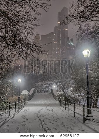 Gapstow Bridge is one of the icons of Central Park Manhattan in New York City during snow storm at night