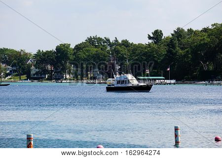 HARBOR POINT, MICHIGAN / UNITED STATES - AUGUST 3, 2016: A boat is anchored off the shore of Harbor Point.