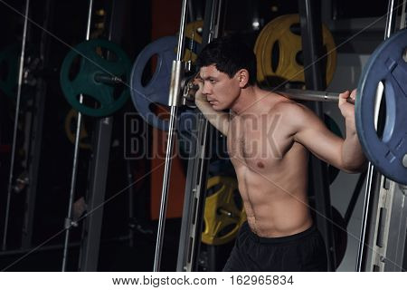 Half Length Portrait Of Athletic Man Doing Squats Working Out With Barbell.