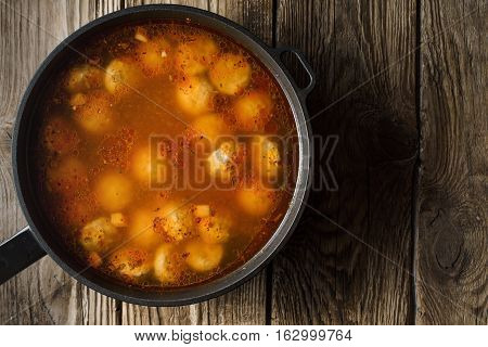Cooked meatballs in a stewpot on the old boards horizontal copy space
