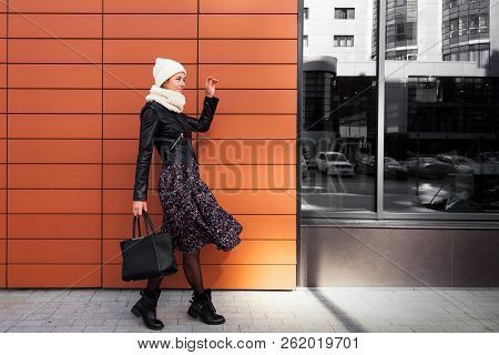 Young Female Student In Warm Autumn Clothes Coming Out Of The House With A Backpack With Books  Arou