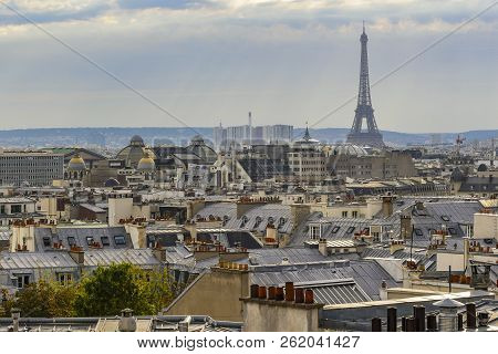 The Roofs Of Paris And Its Chimneys Under A Clouds Sky