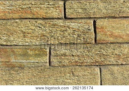 Rough texture. Stone bricks in a wall with sunset light. Horizontal and vertical lines.